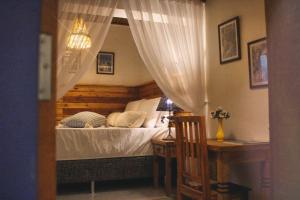 贝洛奥里藏特Pousada Caminhos de Minas Belo Horizonte的一间卧室配有一张床和一张桌子,桌子上配有四柱床。