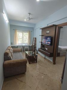 马迪凯里Kamadhenu Residency Homestay Hotel Coorg Madikeri的客厅配有沙发和桌子