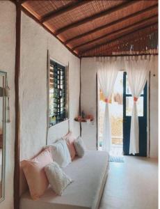 伊尔哈德博伊巴Eco-Pousada Casa Bobô的一间设有床铺的卧室,位于带窗户的房间内