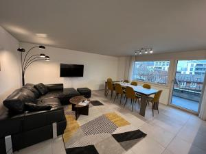 施维茨Apartment No 7 Mythenblick Schwyz 10 Min to Stoos的客厅配有黑色沙发和桌子