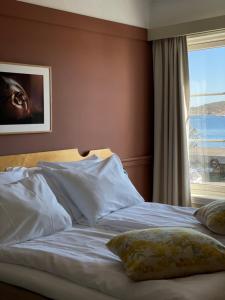 里瑟尔里瑟尔酒店的卧室内的一张带白色床单和窗户的床
