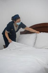 库库塔Hotel Exelsior的蒙面中的女人正在做床
