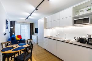 米兹多洛杰Balticus Apartamenty Standard Promenada Gwiazd 14的厨房以及带桌椅的起居室。