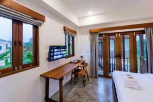 攀牙Phang Nga Origin Hotel的一间卧室配有书桌、一张床和窗户。