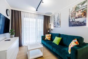 米兹多洛杰Balticus Apartamenty Standard Promenada Gwiazd 14的客厅配有绿色沙发和电视