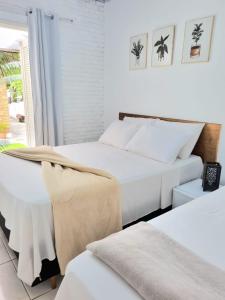 乌巴图巴Yabás Praia的一间卧室设有两张床和窗户。