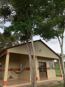 北瓜拉西亚巴Chalés Recanto的前面有两棵树的小房子