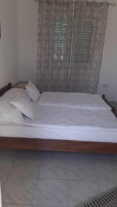 玛里纳Apartments Zdenka的一张带白色床单和枕头的大型木制床