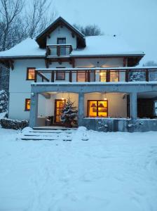 加沃尔金卡Gościniec Śliwkula的前面的地面上积雪的房子