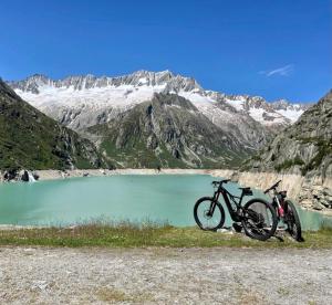 古尔特纳伦Casa Restelli OG - nahe Andermatt Gotthard的停在山湖前的摩托车