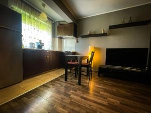 奥拉迪亚Prima Residence Apartment的客厅配有桌子和电视