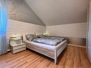 比赫莱尔塔尔A&D Apartment+Ferienwohnung/Elsasser Blick的一间卧室配有一张床,铺有木地板