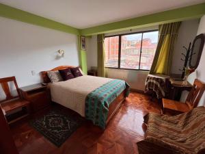 拉巴斯伊斯坎瓦雅旅馆的一间卧室设有一张床、一个窗口和一把椅子