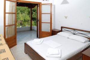 米利纳Zouzoula House的一间卧室设有一张床和一个阳台