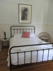本迪戈The Artist's Cottage的一间卧室配有一张红色枕头的床