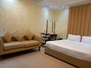 拉斯阿尔卡麦Holiday Homes的一间卧室配有一张床和一张沙发