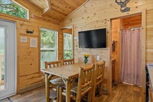 克恩维尔Deluxe little cabin 2 min stroll to Kern River的用餐室配有木桌、椅子和平面电视。
