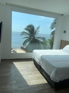 卡塔赫纳Hotel Caribbean Cartagena的卧室设有海景大窗户