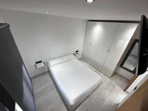 卡门港Princesa 202的卧室配有白色的床和白色橱柜。