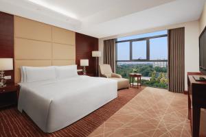 顺义北京临空皇冠假日酒店的卧室设有白色的床和大窗户