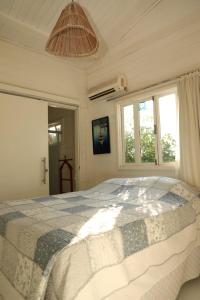阿拉卡茹Vila Eco SPA的一间带一张大床的卧室,位于带窗户的房间内