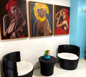 卡塔赫纳Luna Cartagena Airport Hotel的墙上有三幅画作,画有女人