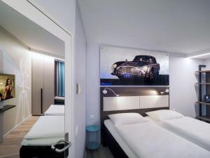 洛迦诺宜必思洛迦诺酒店的一间设有两张床的房间和一张汽车照片