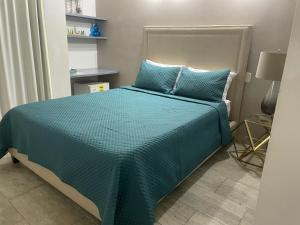 卡塔赫纳Hotel Boutique Casa Mar的一间卧室配有一张带蓝色棉被和枕头的床