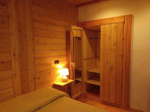 韦尔南泰Albergo Martinet的一间卧室配有一张床、一盏灯和一个衣柜