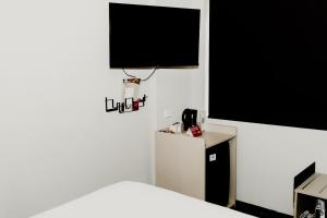 伊萨山Nightcap at Barkly Hotel的一间设有一张床和墙上电视的房间