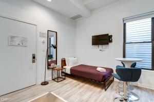 芝加哥Chicago Second Floor Studio by 747 Lofts的一间卧室配有一张床、一台电视和一把椅子