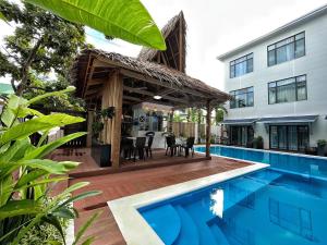 CatagnanSiargao Seasky Resort的一座带游泳池的房子和一座带房子的甲板