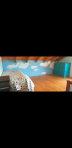 梅洛Cabaña Thaqu的卧室配有一张墙壁上涂有云彩的床。