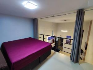 瓜拉图巴GUARATUBA LOFTS的带窗户的客房内的紫色床