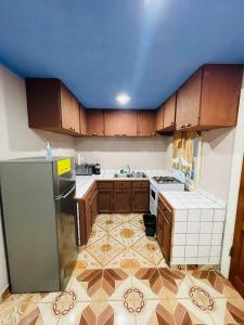 Six HutsCoco Bahia Apartment的厨房配有木制橱柜和蓝色天花板