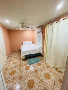 Six HutsCoco Bahia Apartment的卧室配有1张床,铺有瓷砖地板。