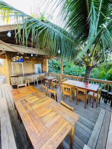 Six HutsBahia Azul Apartment的一个带木桌、长凳和棕榈树的庭院