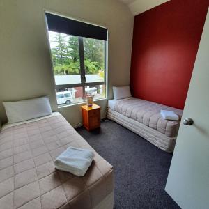 罗托鲁瓦Kuirau Chalet Villa 3-bedroom Twin Lake的一间卧室设有两张床和窗户。