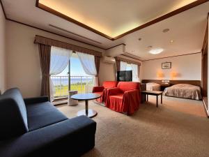 奄美珊瑚棕榈旅馆的客厅配有沙发和1张床