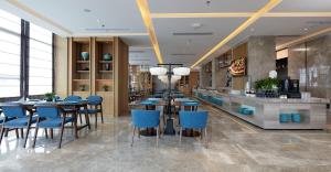 扬州扬州瘦西湖君亭酒店的一间设有蓝色桌椅的餐厅和一间酒吧