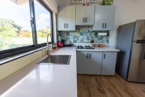 璜多里奥Beach Apartment Villas Jubey, Emotion access的厨房配有白色橱柜、水槽和窗户。