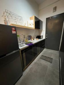 八打灵再也Breeze Cottage@Empire Damansara的厨房配有黑色冰箱和台面