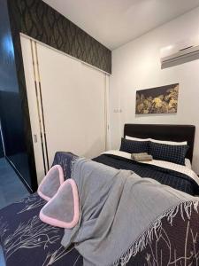八打灵再也Breeze Cottage@Empire Damansara的一间卧室配有一张床,旁边配有一张粉红色椅子