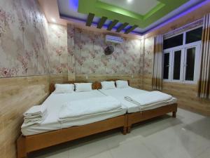 惹岛Khách sạn QUỲNH ANH的一间卧室配有一张带白色床单的大床