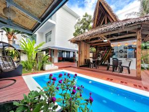 CatagnanSiargao Seasky Resort的一个带游泳池和房子的户外庭院