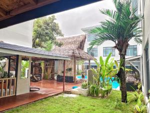 CatagnanSiargao Seasky Resort的一座棕榈树的开放式庭院和一座建筑