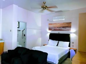 班塔延岛Marino Bungalows的卧室配有白色的床和吊扇