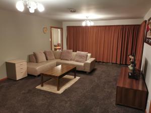 基督城Airport accommodation的带沙发和咖啡桌的客厅