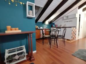 米兰Mercanti Attic Version的厨房以及带蓝色墙壁和椅子的用餐室。