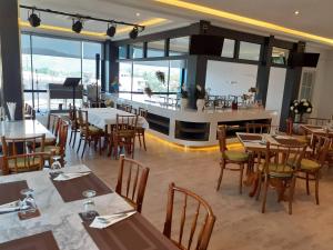 Ban Lum ThanKarnyapha Hotspring hotel的一间带桌椅的餐厅和一间酒吧
